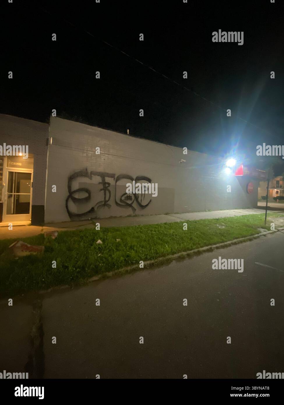 ScoreGang, un sous-ensemble de Detroit Crips, étiquette « ETGC » sur la vitrine des alcools locaux, peinture noire, « 3 » chevauchant « T » ; « Rip » à l'intérieur de « C » ; 12,5 pi x 7,5 pi - Image de stock capturée avec un smartphone