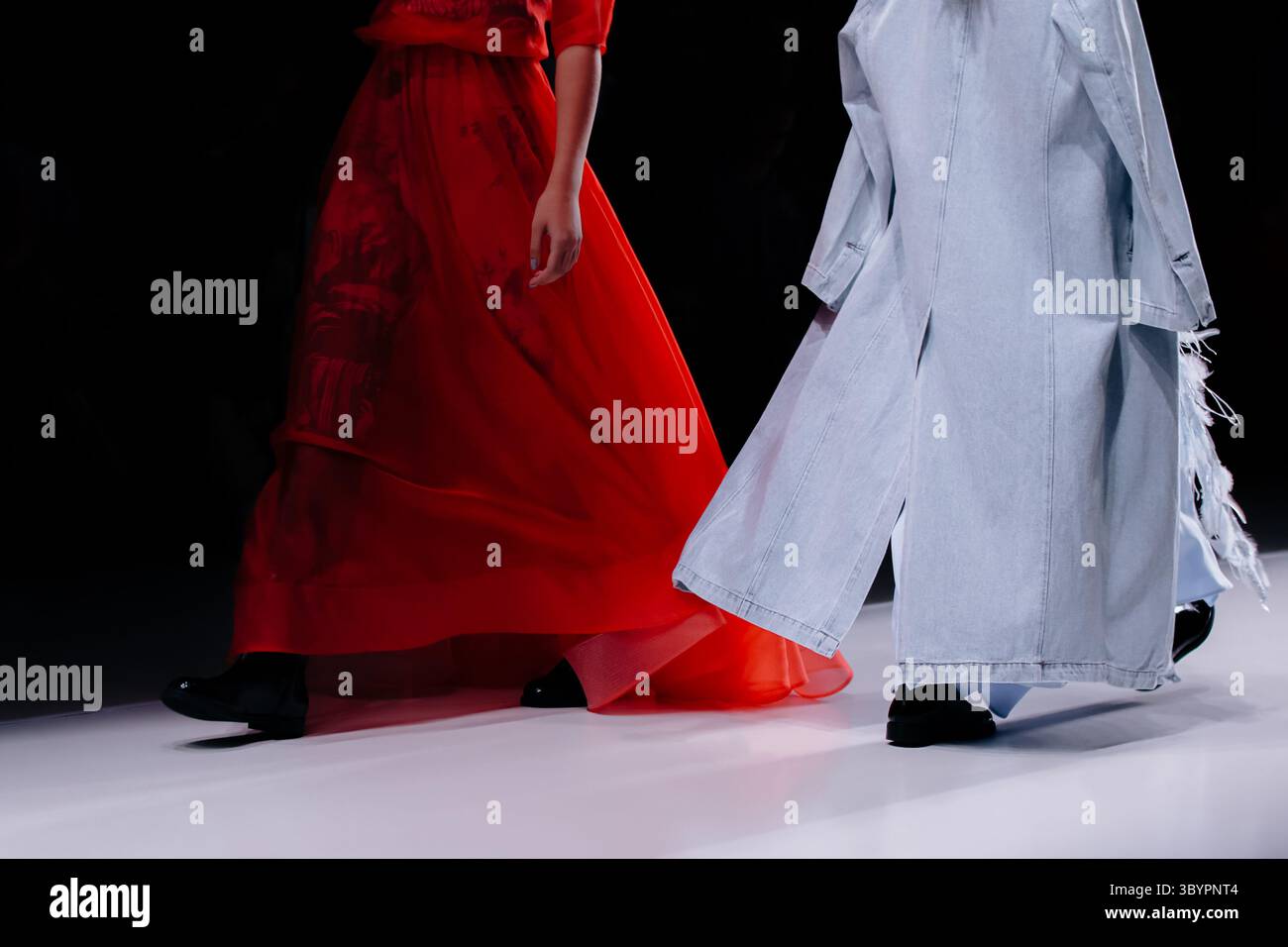 Tenues élégantes pour femmes, robe longue rouge vif et manteau en denim bleu, mannequins de mode marchant le défilé de mode Runway Banque D'Images