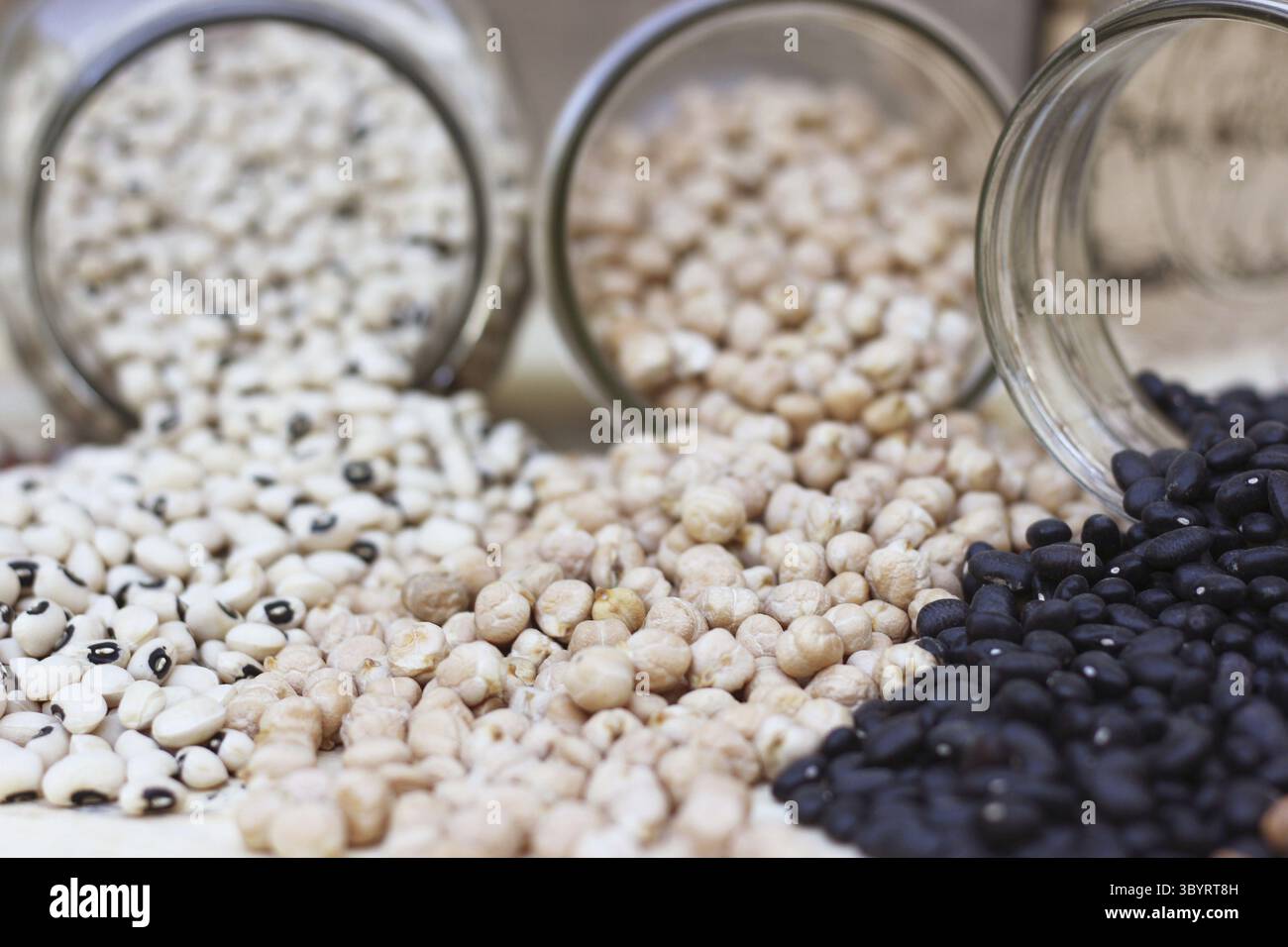 Pots de pois aux yeux noirs, pois chiches, haricots noirs et haricots Pinto renversés dans la cuisine Banque D'Images