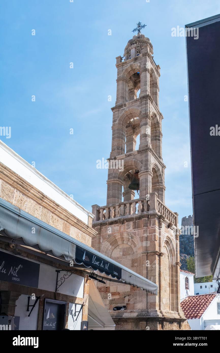 Rhodes, Grèce - 15 octobre 2024 : clocher historique à Lindos, Rhodes, Grèce, entouré de bâtiments méditerranéens et d'un ciel bleu clair. Mediterran Banque D'Images