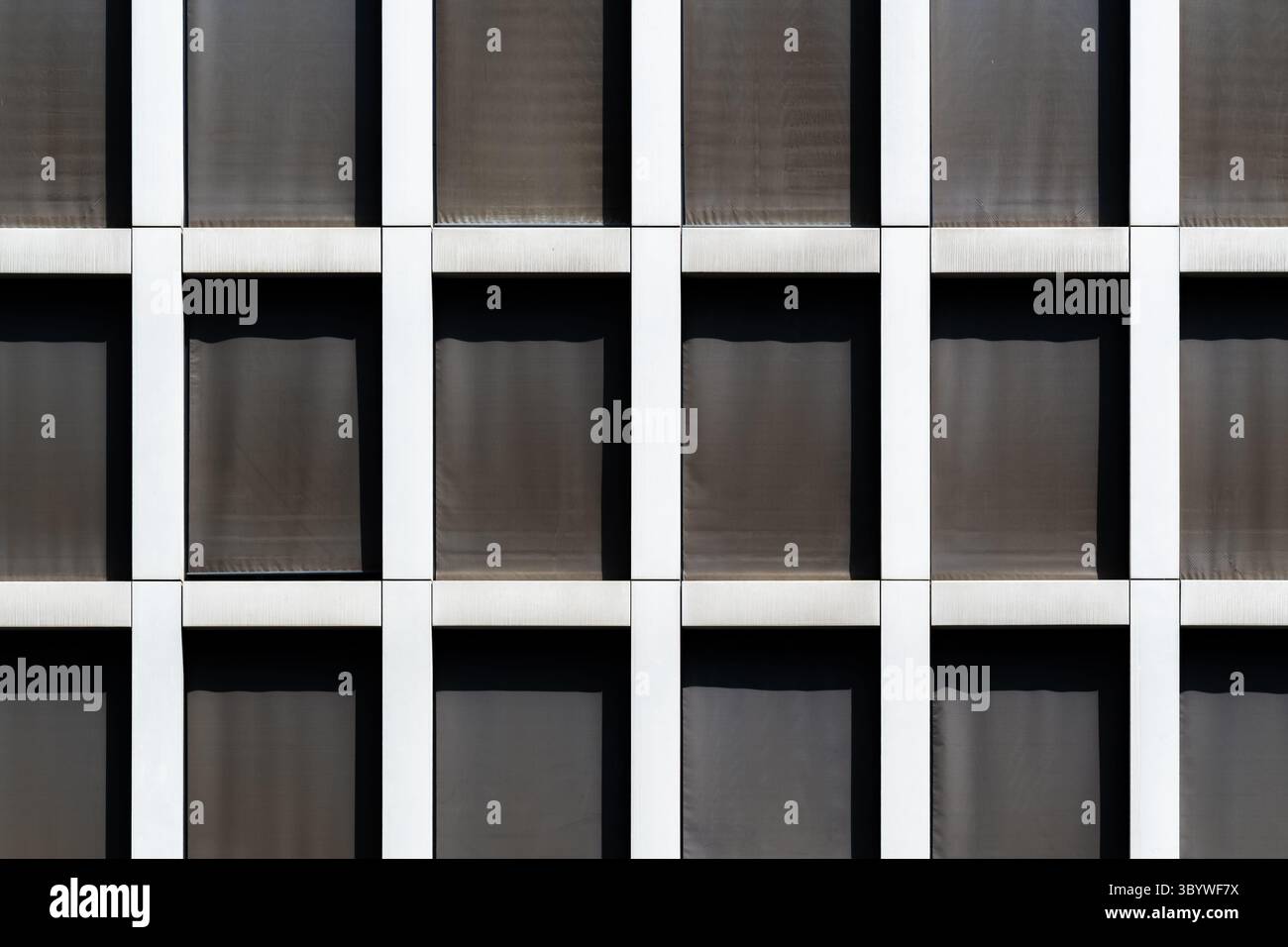 Façade de bureau minimaliste avec fenêtres noires profondes répétitives Banque D'Images