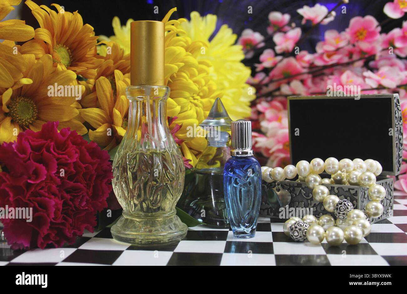 Fleurs avec parfums et bijoux sur la table de coiffeuse Banque D'Images
