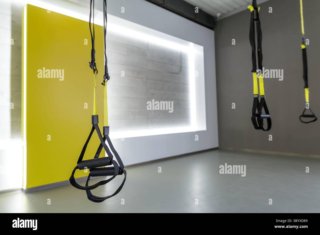 Intérieur de salle de sport contemporain avec sangles de suspension prêtes pour les entraînements fonctionnels de groupe et les séances d'entraînement en résistance Banque D'Images
