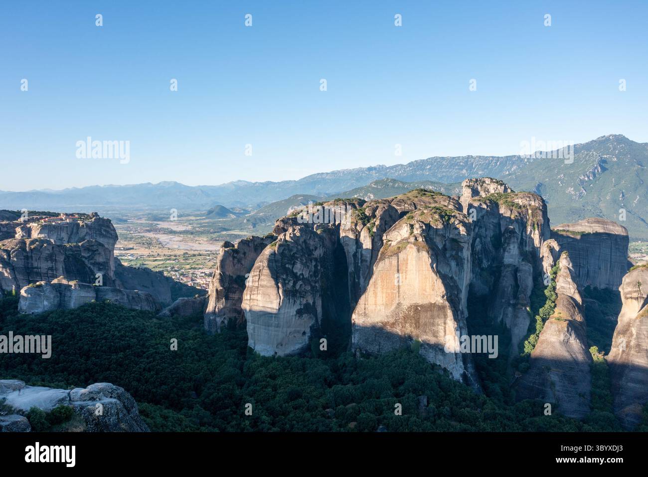 Vue aérienne d'une grande formation rocheuse dans les Météores Grèce avec des montagnes en arrière-plan Banque D'Images