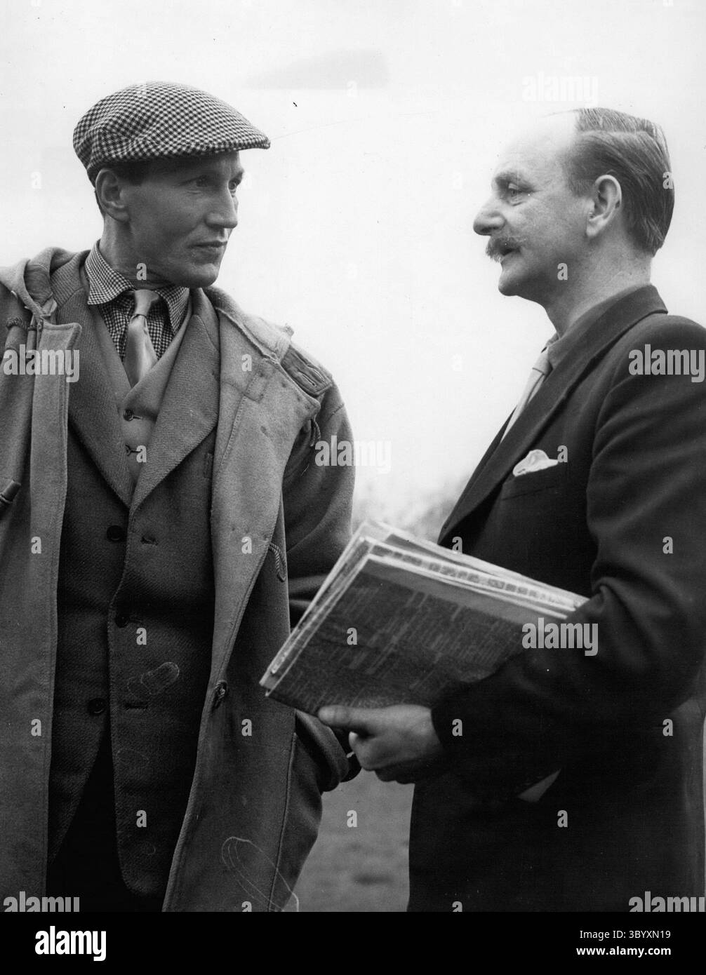 Dec. 14, 1957 - elle a formé le ''Miracle Miler'' Roger Bannister Franz Stampfl l'entraîneur né autrichien. La photo montre Franz Stampfl (à gauche) l'homme qui a entraîné Roger Bannister dans son incroyable course de 3 min 59,4 s vu alors qu'il discute avec le journaliste John Macadan. Franz est né à Vienne, mais il est dans ce pays depuis 1937 et s'est vu offrir le poste d'entraîneur national d'athlétisme en Australie et dit qu'il pourrait aller à Melbourne avec sa famille au printemps prochain. (Crédit image : © Keystone Press Agency/ZUMA Press Wire) Banque D'Images