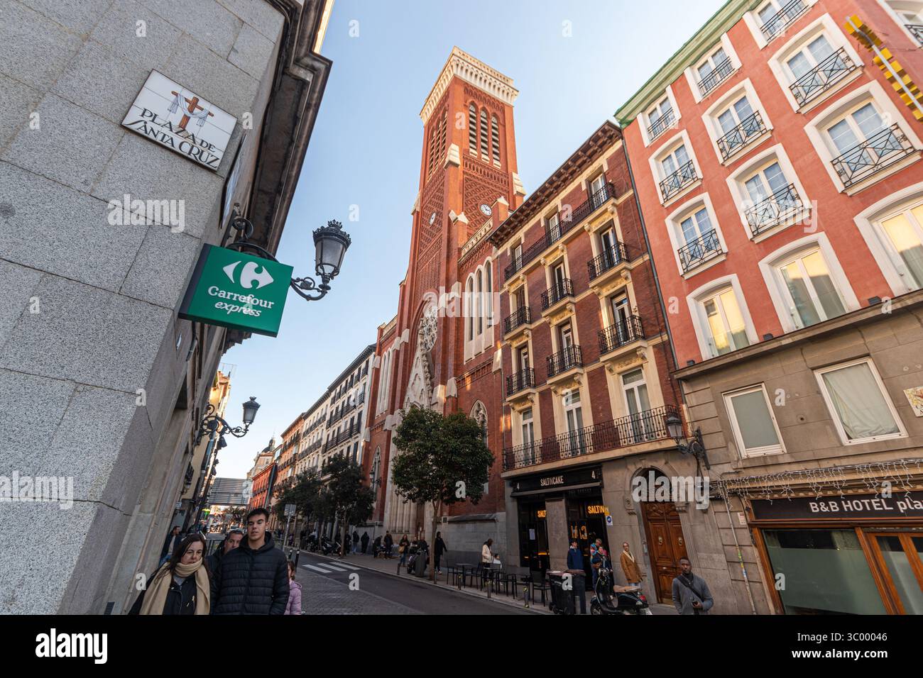 Madrid, Espagne. Briques néogothiques et pierre blanche Eglise de Santa Cruz à la rue Atocha, avec une entrée en arc pointu, rosace et haute tour levant Banque D'Images