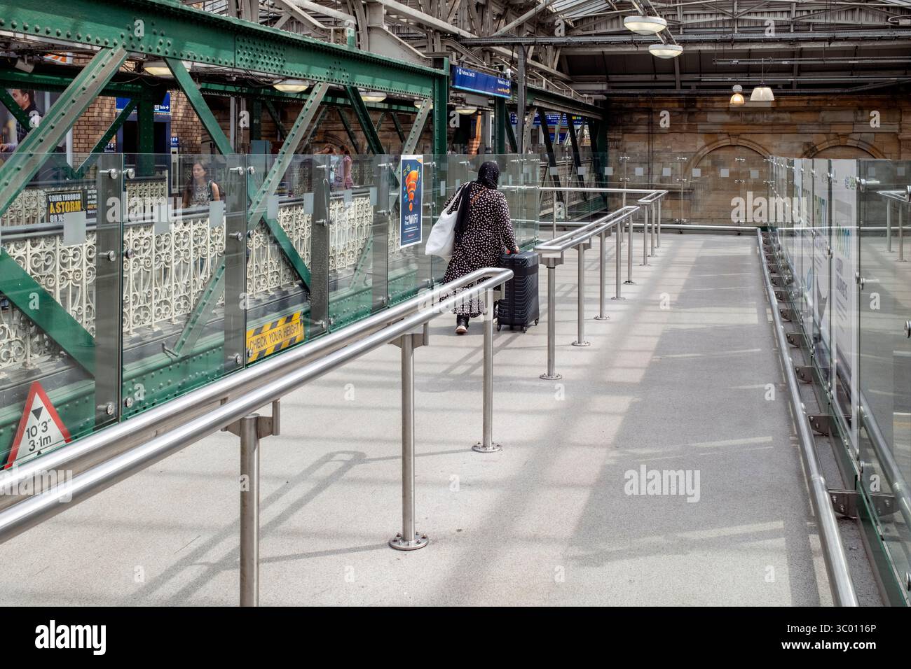 Une voyageuse solitaire tirant une affaire à Waverley Station, Édimbourg, Écosse, Royaume-Uni. Banque D'Images