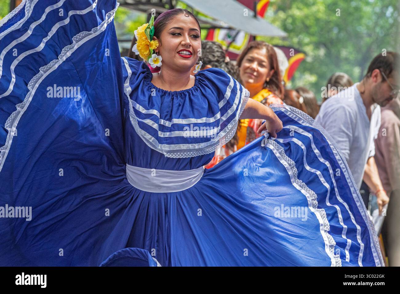 Danseuse salvadorienne colorée en robe bleue traditionnelle se produisant lors d'un événement culturel en plein air lors de l'événement du Festival, Calgary, Alberta Banque D'Images