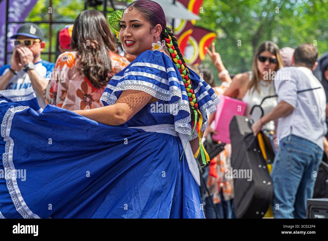 Danseuse salvadorienne colorée en robe bleue traditionnelle se produisant lors d'un événement culturel en plein air lors de l'événement du Festival, Calgary, Alberta Banque D'Images