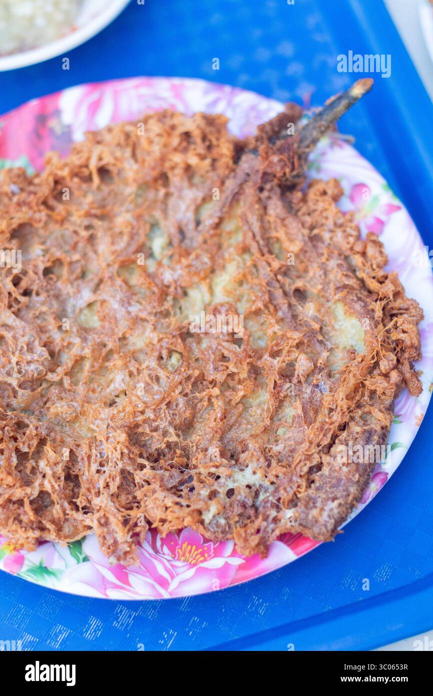 Tortang talong servi avec des bords croustillants sur une assiette dans une carinderia locale aux Philippines, un plat de rue philippin d'aubergines et d'œufs bien aimé Banque D'Images Tortang talong servi avec des bords croustillants sur une assiette dans une carinderia locale aux Philippines, un plat de rue philippin d'aubergines et d'œufs bien aimé Banque D'Images
