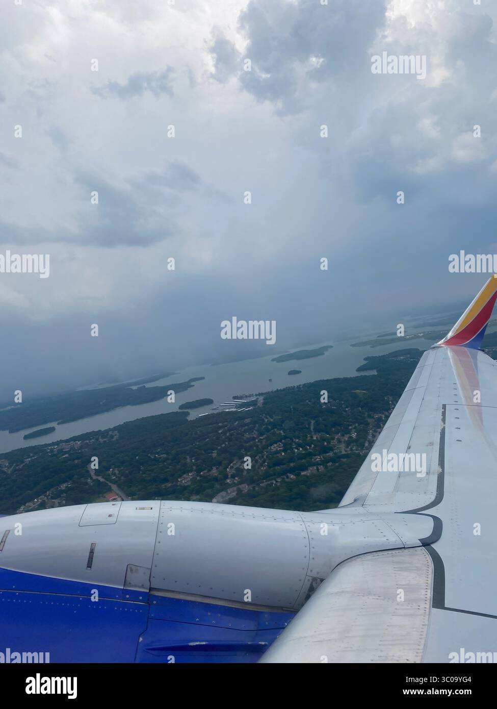 Vue depuis la fenêtre de l'avion en route vers Los Angeles, montrant les nuages, les ailes et le paysage ci-dessous ; photographiée par les habitants de Five points. Banque D'Images