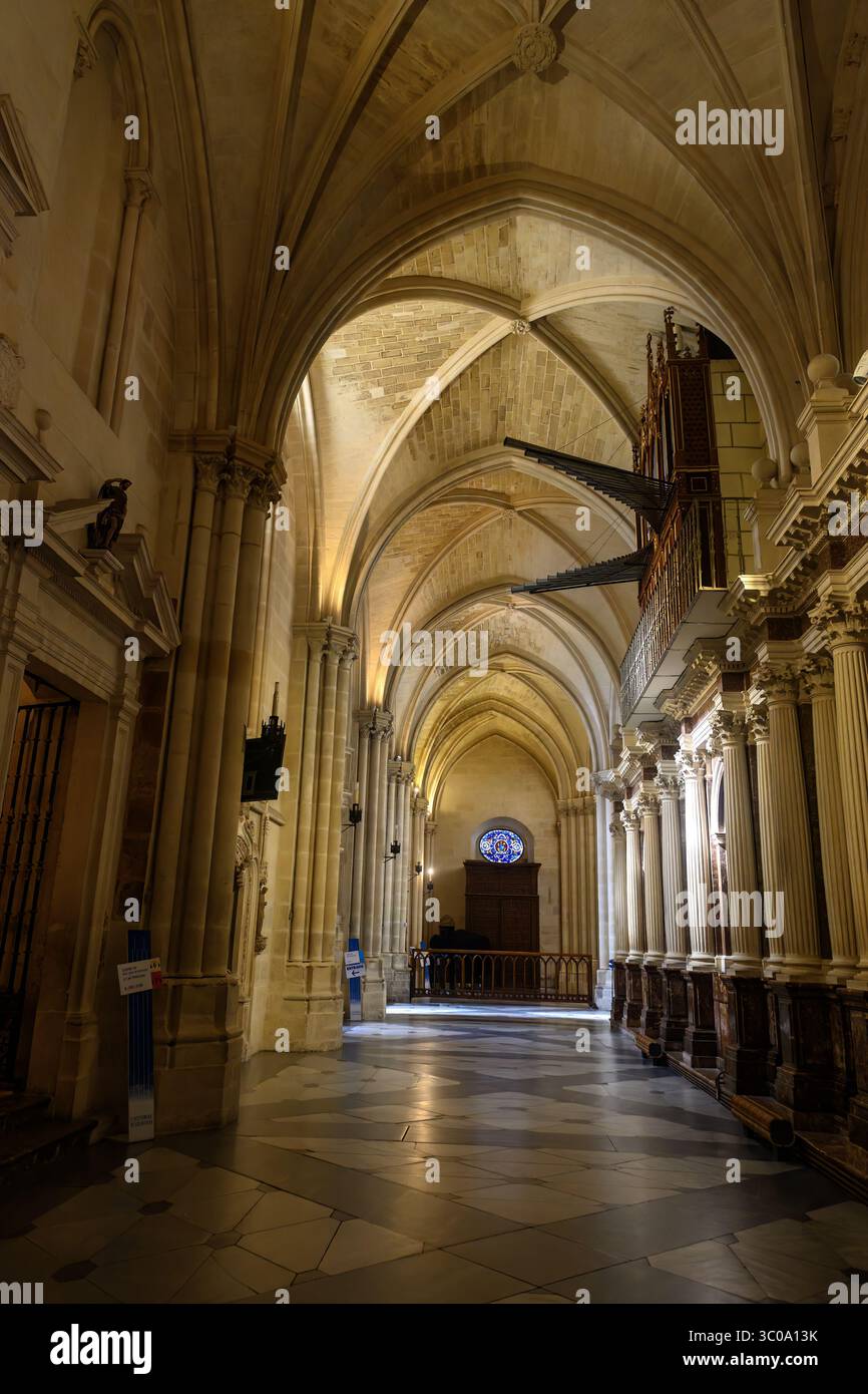 Ambulatoire gothique avec voûtes nervurées, orgue à pipe et éclairage intérieur doux Banque D'Images