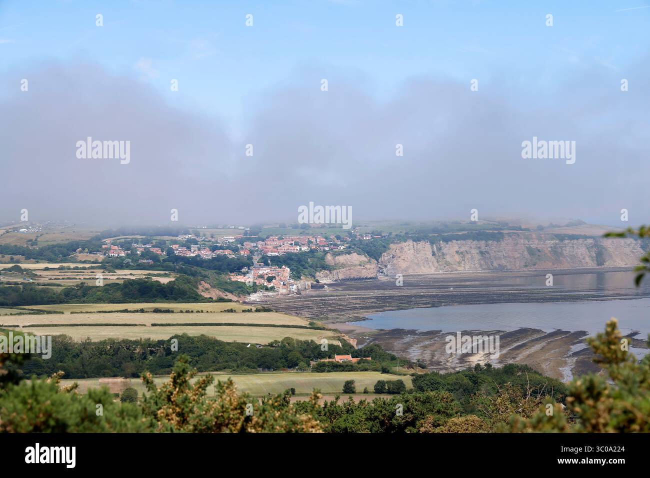 Robin Hood's Bay, North Yorkshire, Angleterre, vu de Ravenscar, à environ 4 miles de distance. - 12 juillet 2025 photo de Andrew Higgins/Thousand Word Media Banque D'Images