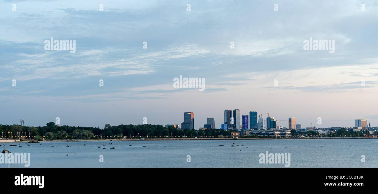 Horizon de Tallinn à travers l'eau de Pirita avec des nuages spectaculaires - paysage urbain côtier de la Baltique avec réflexion, silhouette urbaine et premier plan naturel Banque D'Images
