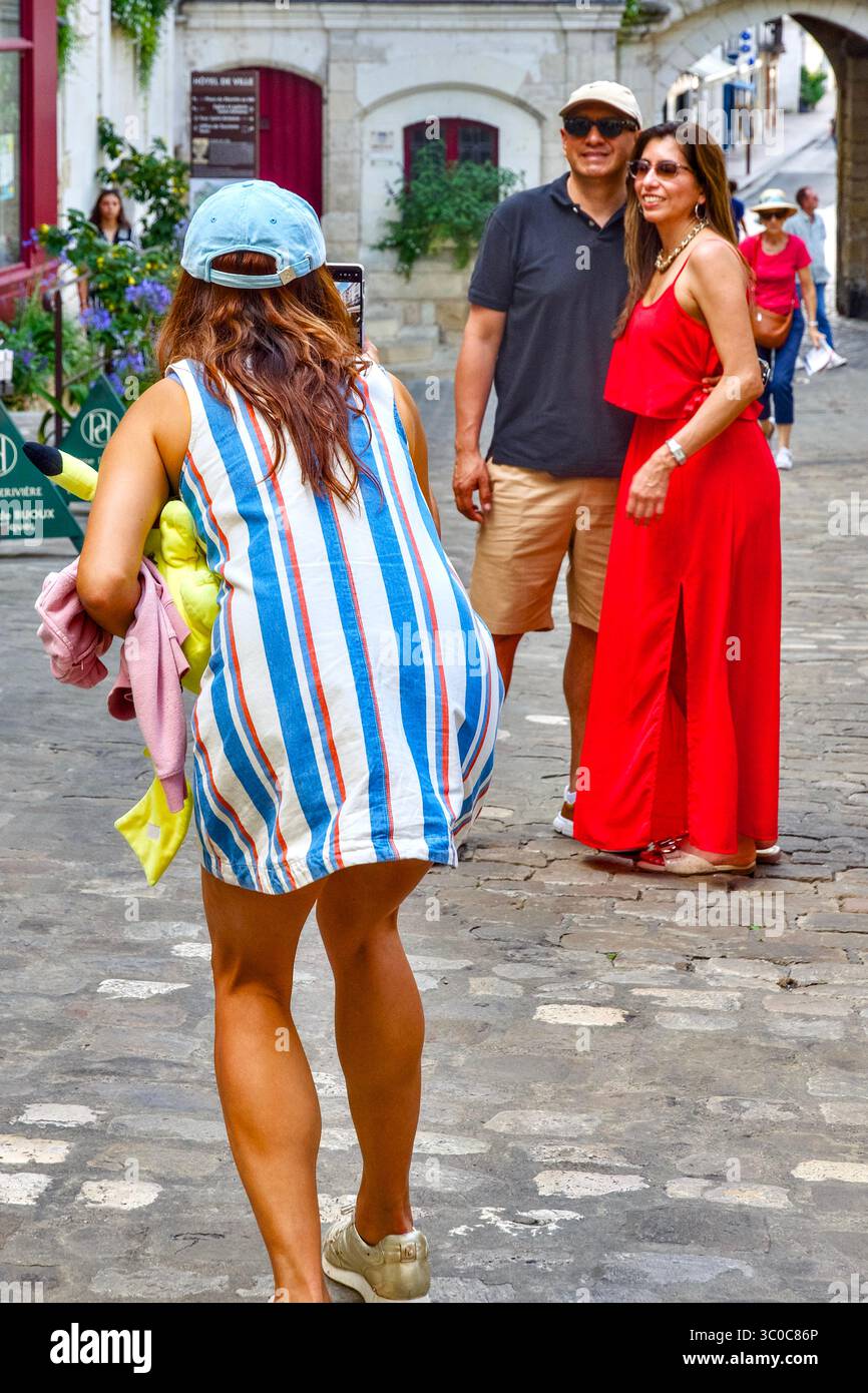 Vue arrière d'une femme en robe rayée (photographier ?) Couple en arrière-plan - Loches, Indre-et-Loire (37), France. Banque D'Images