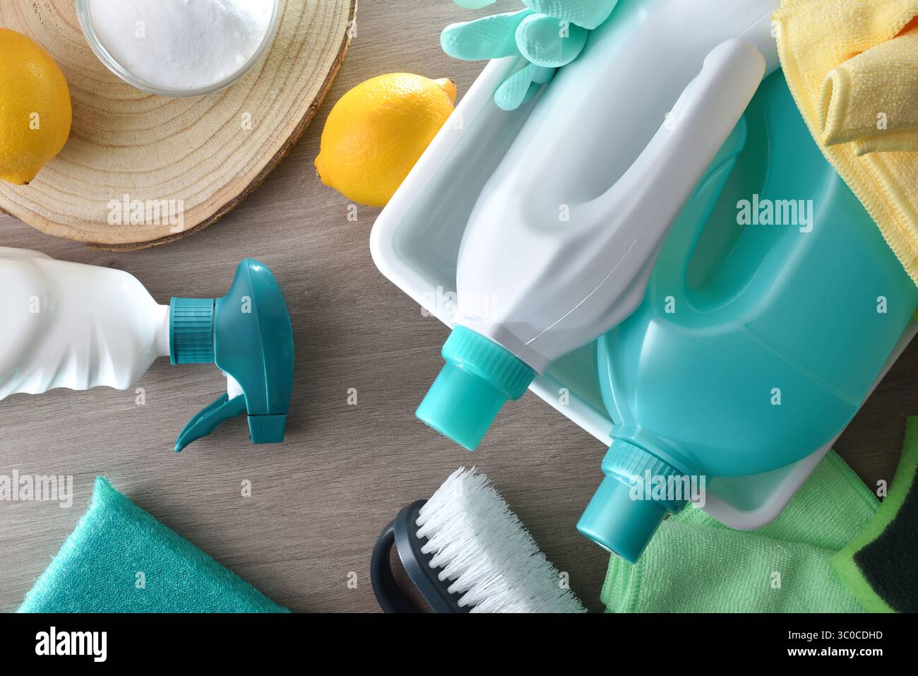 Produits de nettoyage chimiques et naturels sur une table en bois tels que des bouteilles avec des produits désinfectants, chiffons, brosses, citrons et bol avec bicarbonate f Banque D'Images
