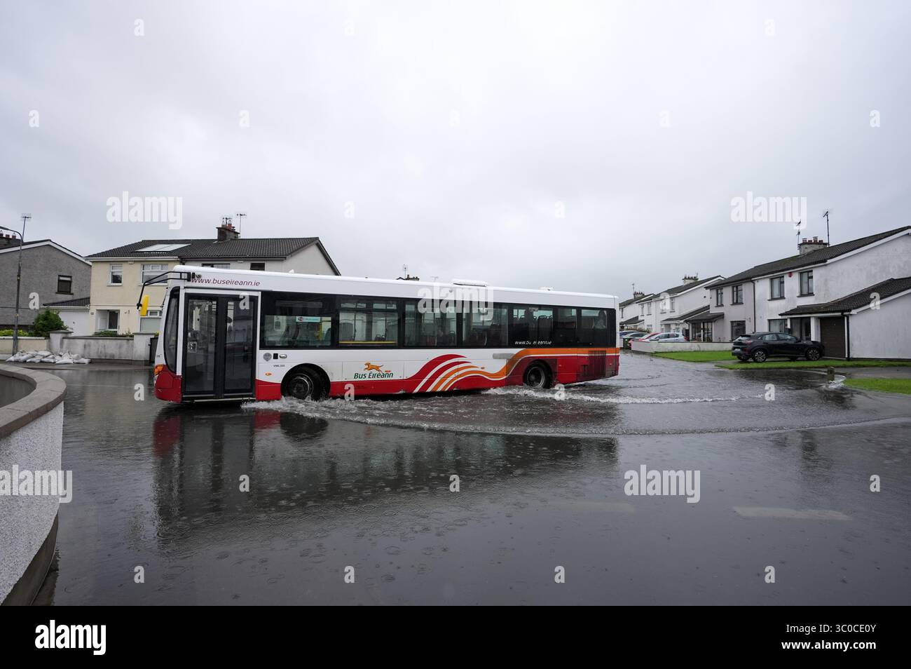 Un bus traverse les eaux de crue sur le Bay Estate à Dundalk, Co Louth, alors que des avertissements météorologiques orangés étaient en place pour certaines parties de l'Irlande après une nuit de fortes pluies sur l'île. Date de la photo : lundi 21 juillet 2025. Banque D'Images