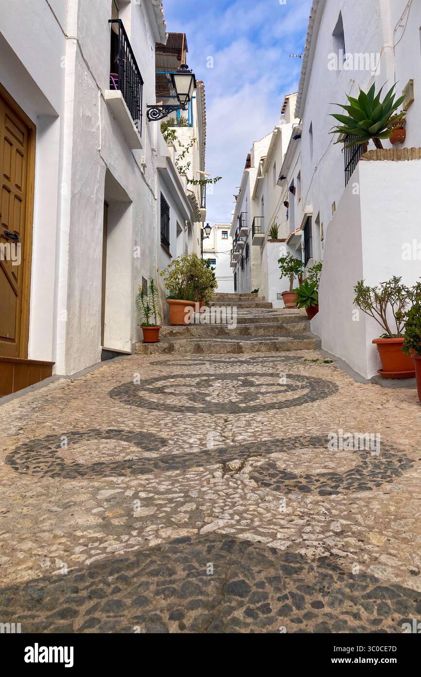 FRIGILIANA, ESPAGNE - 10 MAI 2025 : une promenade paisible dans les charmantes rues étroites, entourées de maisons blanchies à la chaux et de fleurs colorées à Frigil Banque D'Images