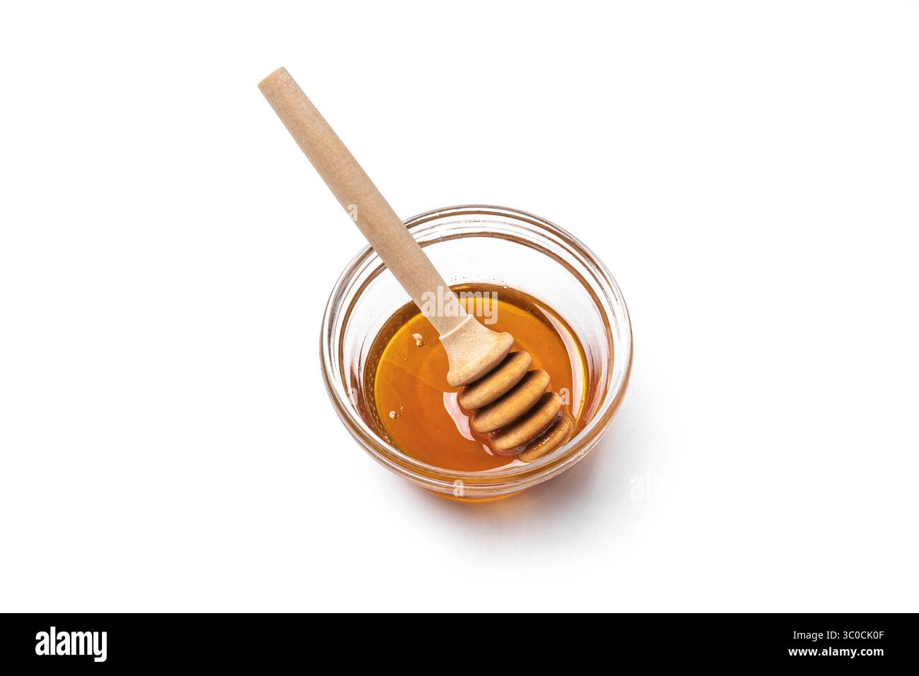 Miel dans un bol en verre avec un plongeur de miel isolé sur fond blanc, élément de design. Miel naturel. Banque D'Images
