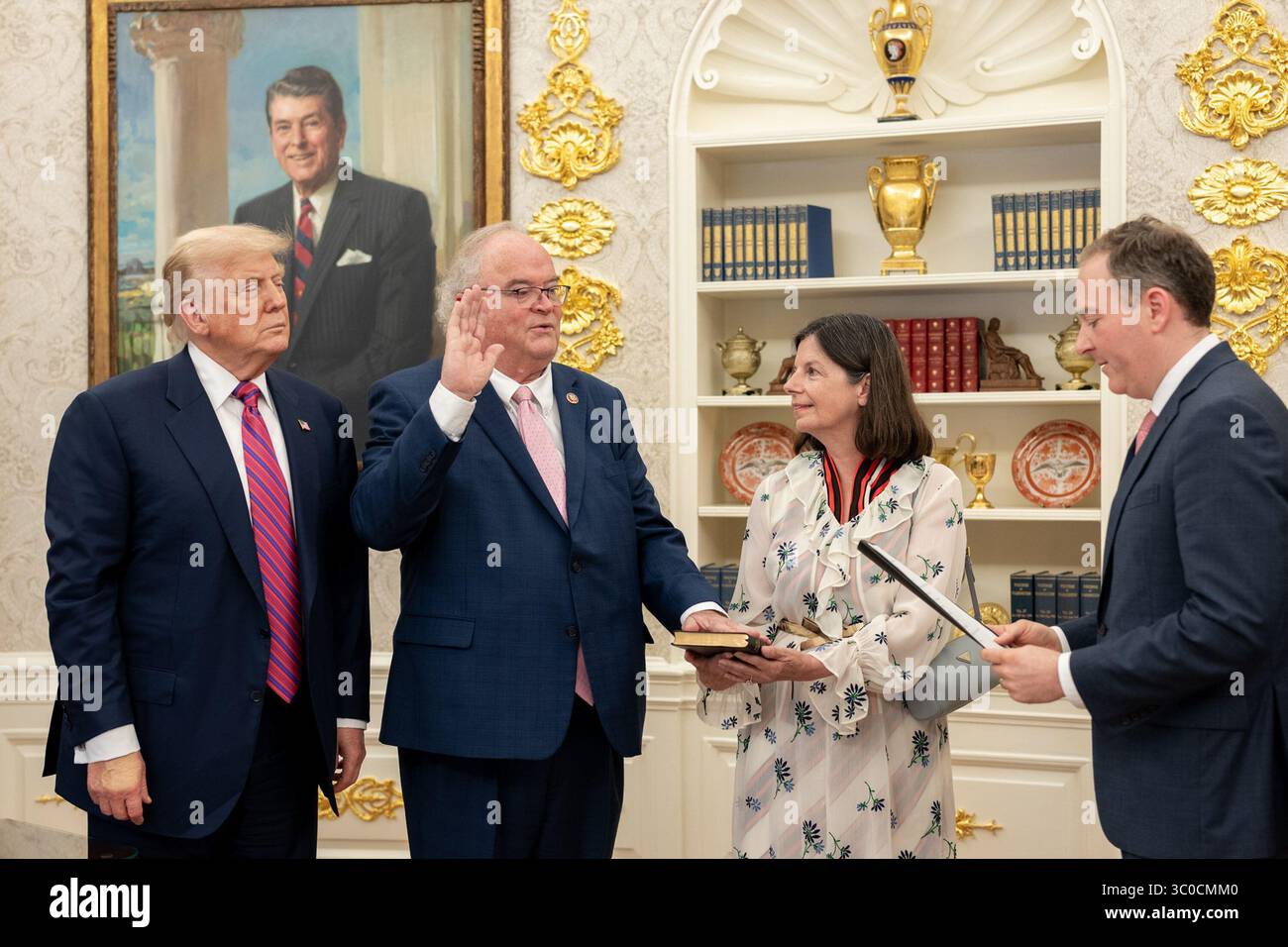 Le président Donald Trump regarde Billy long prêter officiellement serment en tant que commissaire du service des recettes internes par l'administrateur de l'EPA Lee Zeldin dans le bureau ovale de la Maison Blanche le 18 juillet 2025. Des membres de la famille et des fonctionnaires ont assisté à la cérémonie. Un portrait du président Ronald Reagan est vu en arrière-plan. Image reproduite avec l'aimable autorisation de la Maison Blanche. Banque D'Images