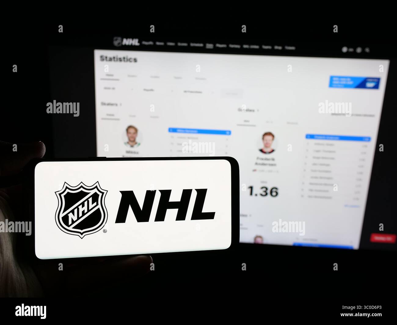 Stuttgart, Allemagne - 2025-05-05 : personne tenant un smartphone avec le logo de la Ligue nationale de hockey (LNH) sur l'écran devant le site Web. Banque D'Images