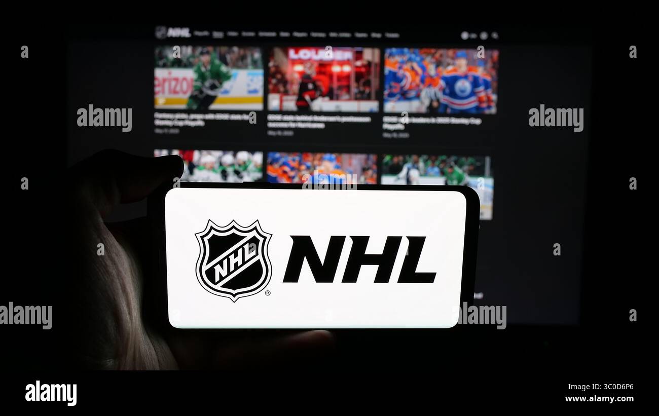 Stuttgart, Allemagne - 2025-05-05 : personne tenant un téléphone portable avec le logo de la Ligue nationale de hockey (LNH) à l'écran devant la page Web. Banque D'Images