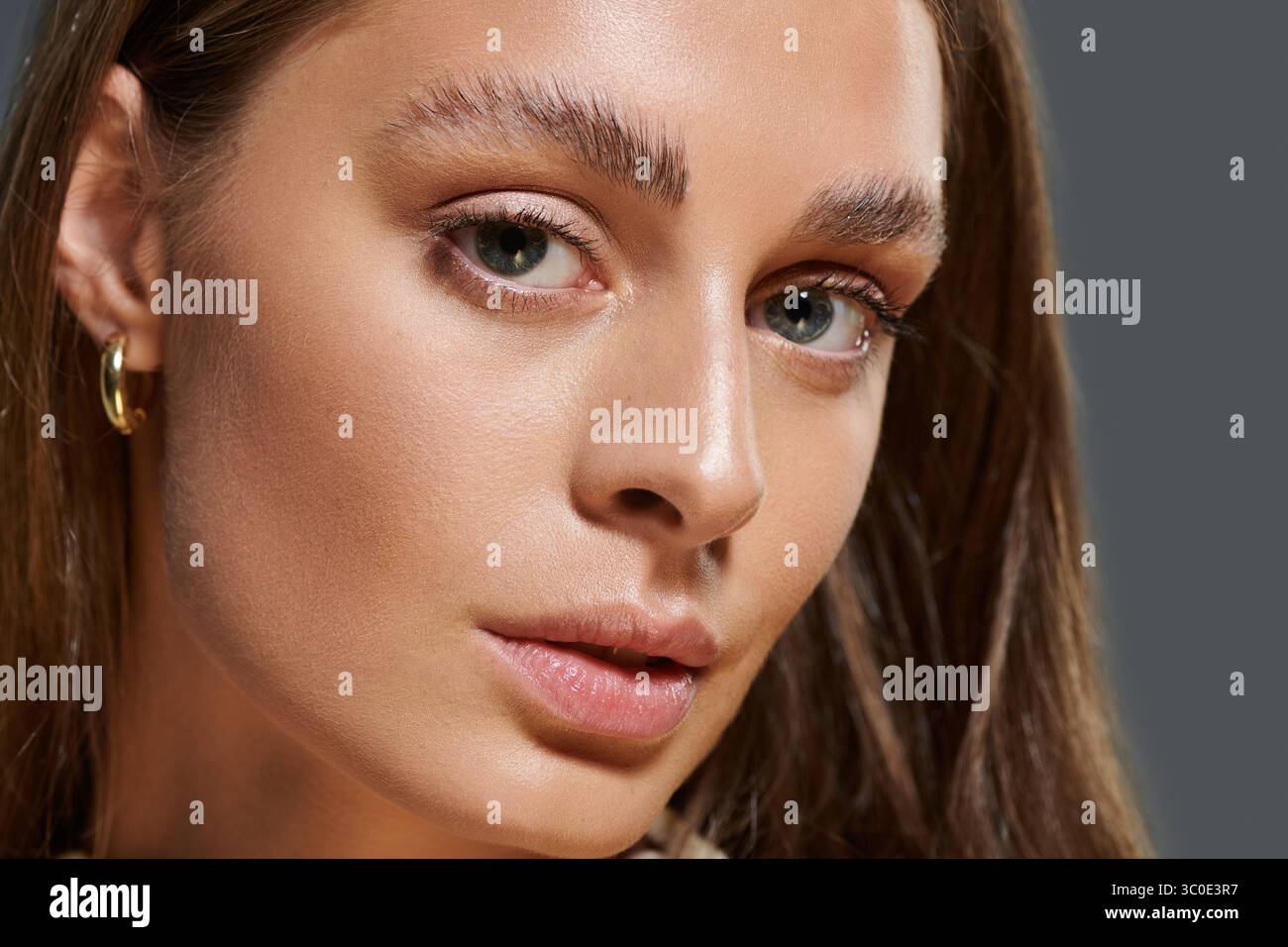 Une jeune femme à la peau bronzée met en valeur sa beauté, exsudant la confiance en elle. Banque D'Images