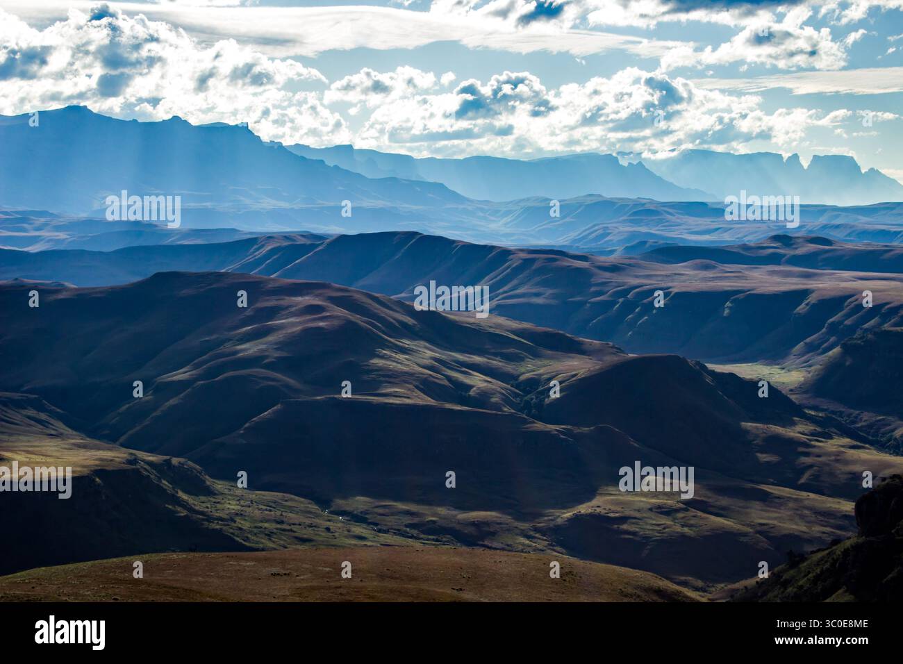 Fin d'après-midi lumière à travers les nuages sur le paysage impraticable des majestueuses montagnes Drakensberg d'Afrique du Sud. Banque D'Images