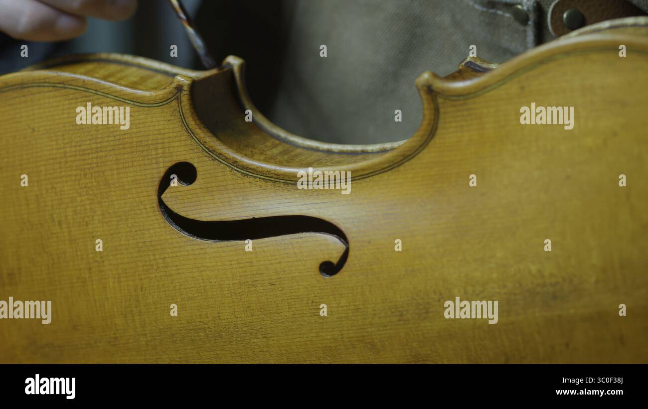 Image d'un trou f d'un violon montrant l'artisanat détaillé et la texture du bois, processus de vernis de violon antique tecnique Banque D'Images