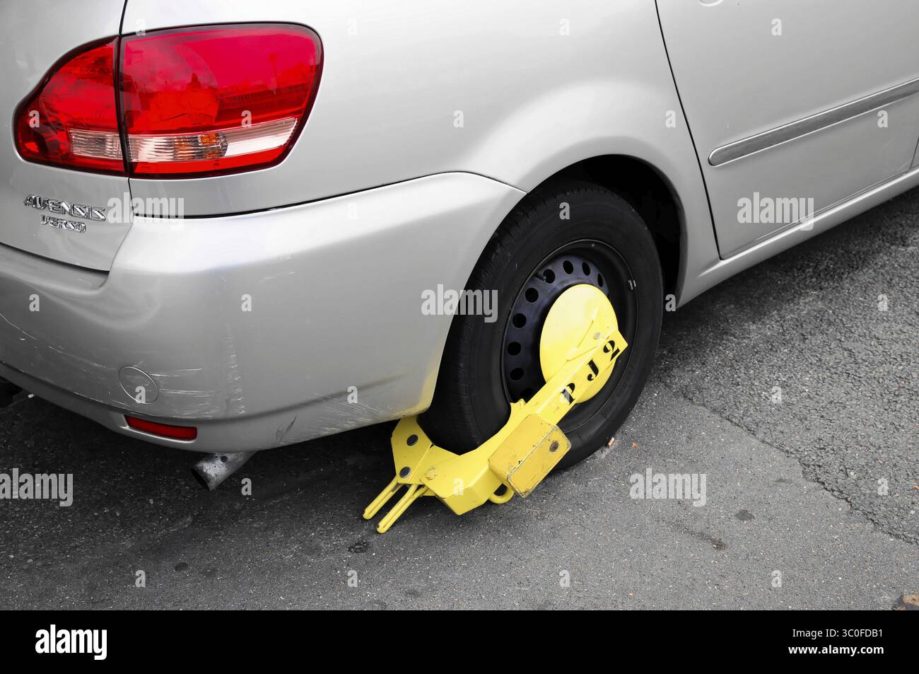 Gros plan d'une voiture avec une pince de roue sur la route, Paris, France Banque D'Images