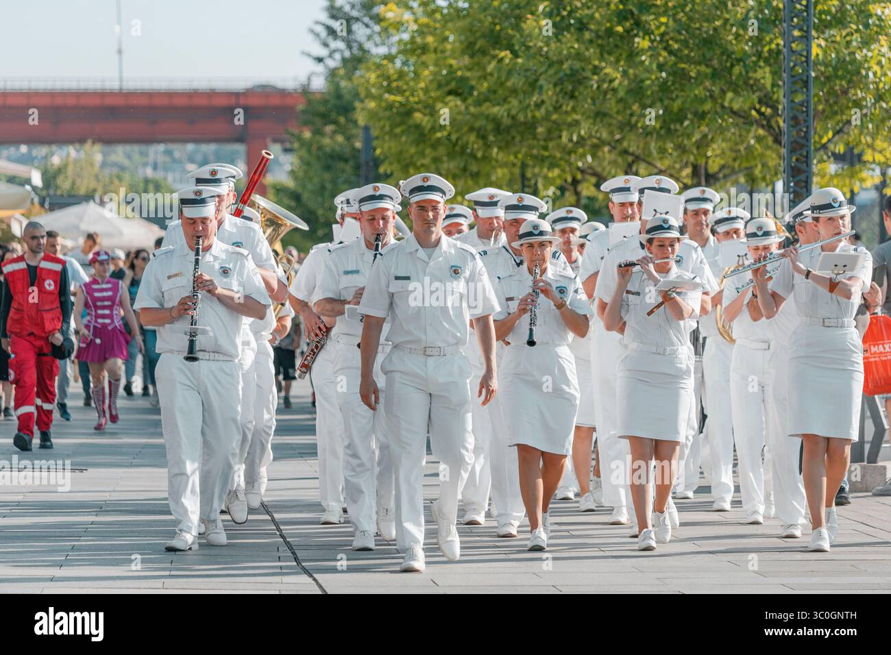 1er juin 2025, Belgrade, Serbie : musiciens vêtus d'uniformes blancs et nets marchant et jouant d'une variété d'instruments à vent Banque D'Images
