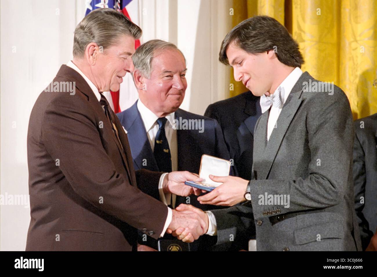 Le président américain Ronald Reagan présente Steve Jobs, co-fondateur américain d'Apple Computer, Inc, avec le National Technology Award 1985 dans la salle est de la Maison Blanche le 19 février 1985. (ÉTATS-UNIS) Banque D'Images
