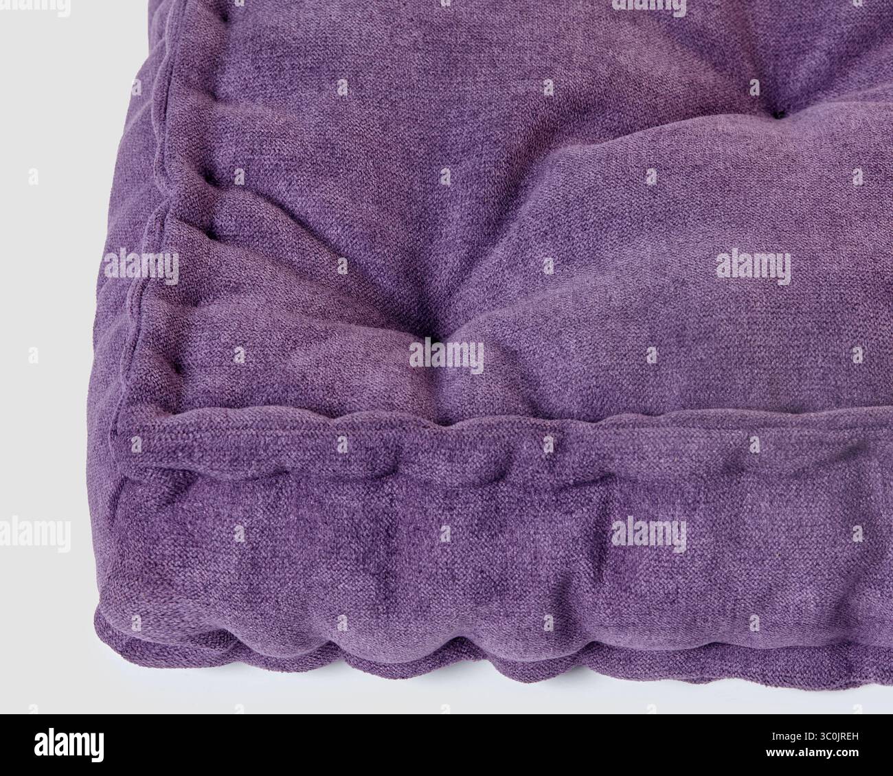Coussin en velours violet avec coutures détaillées, offrant une sensation luxueuse et confortable Banque D'Images