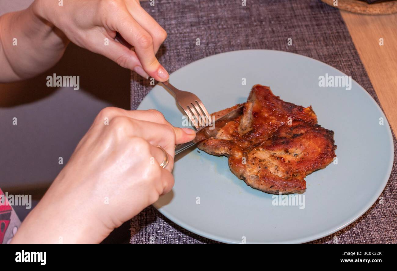 Femme coupée de morceaux de steak sur une plaque en céramique Banque D'Images
