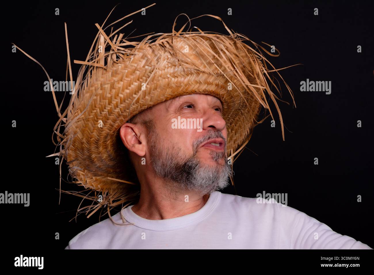 Homme barbu souriant portant chapeau de paille et chemise blanche représentant le personnage du festival Sao Joao au Brésil. Fête traditionnelle. Banque D'Images