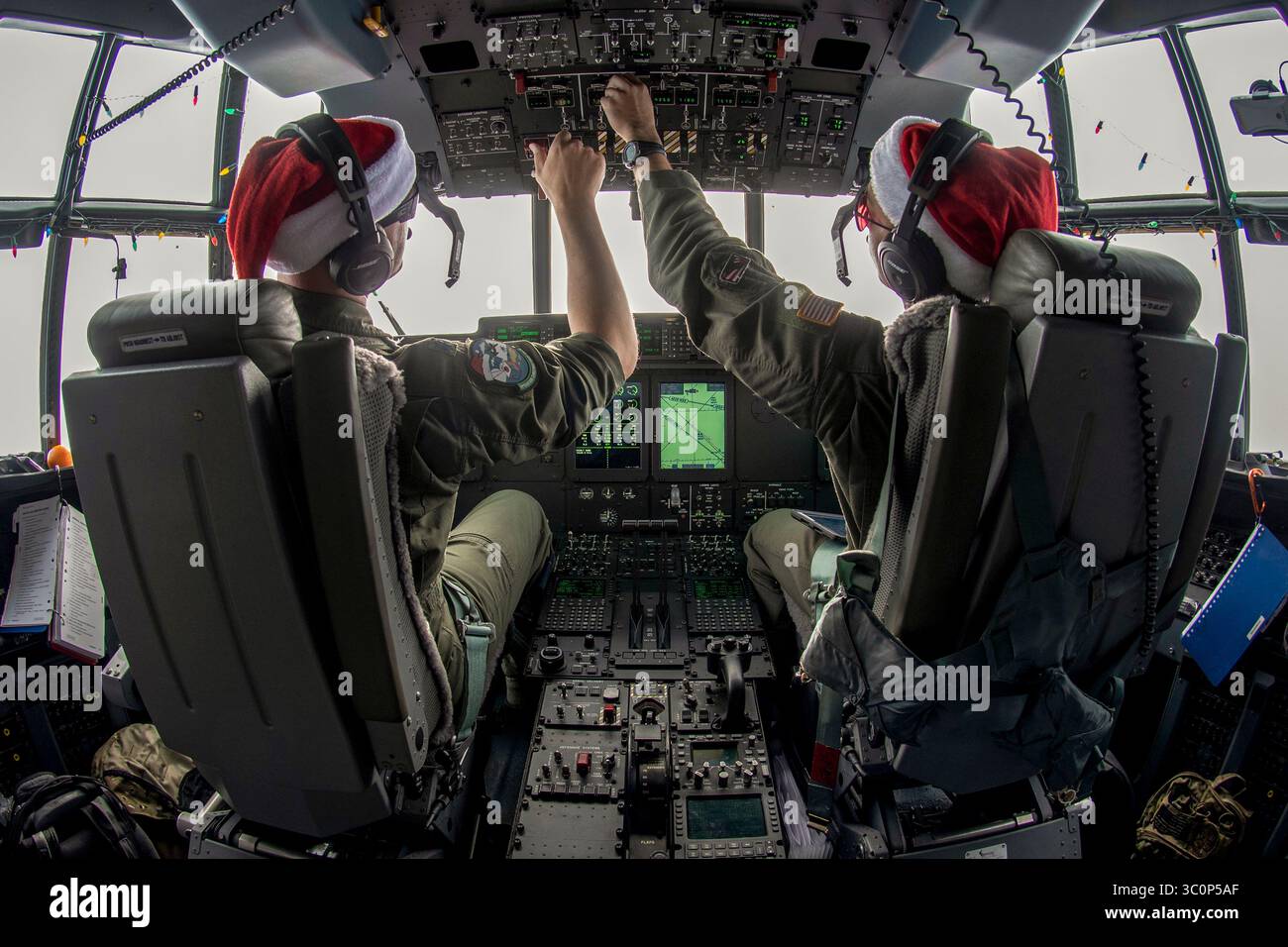 10 décembre 2018 - Andersen Air Force base, Guam - Lt. Col. Barry A. King, commandant adjoint du 374e Groupe des opérations, à gauche, et 1re. Lt. Emery Gumapas, pilote du 36e escadron de transport aérien, à droite, faire des ajustements à bord du Santa 21 sur son chemin pour le largage aérien de fournitures à l'île de Nama, États fédérés de Micronésie pendant l'opération Christmas Drop 2018, Dec. 10, 2018. L'OCD est une mission d'entraînement trilatérale conçue pour donner aux équipages de C-130 de l'US Air Force, de la Japan Air Self-Defense Force (Koku Jietai) et de la Royal Australian Air Force une chance de larguer des fournitures sur des zones de largage non surveillées à travers le Pacifi Banque D'Images
