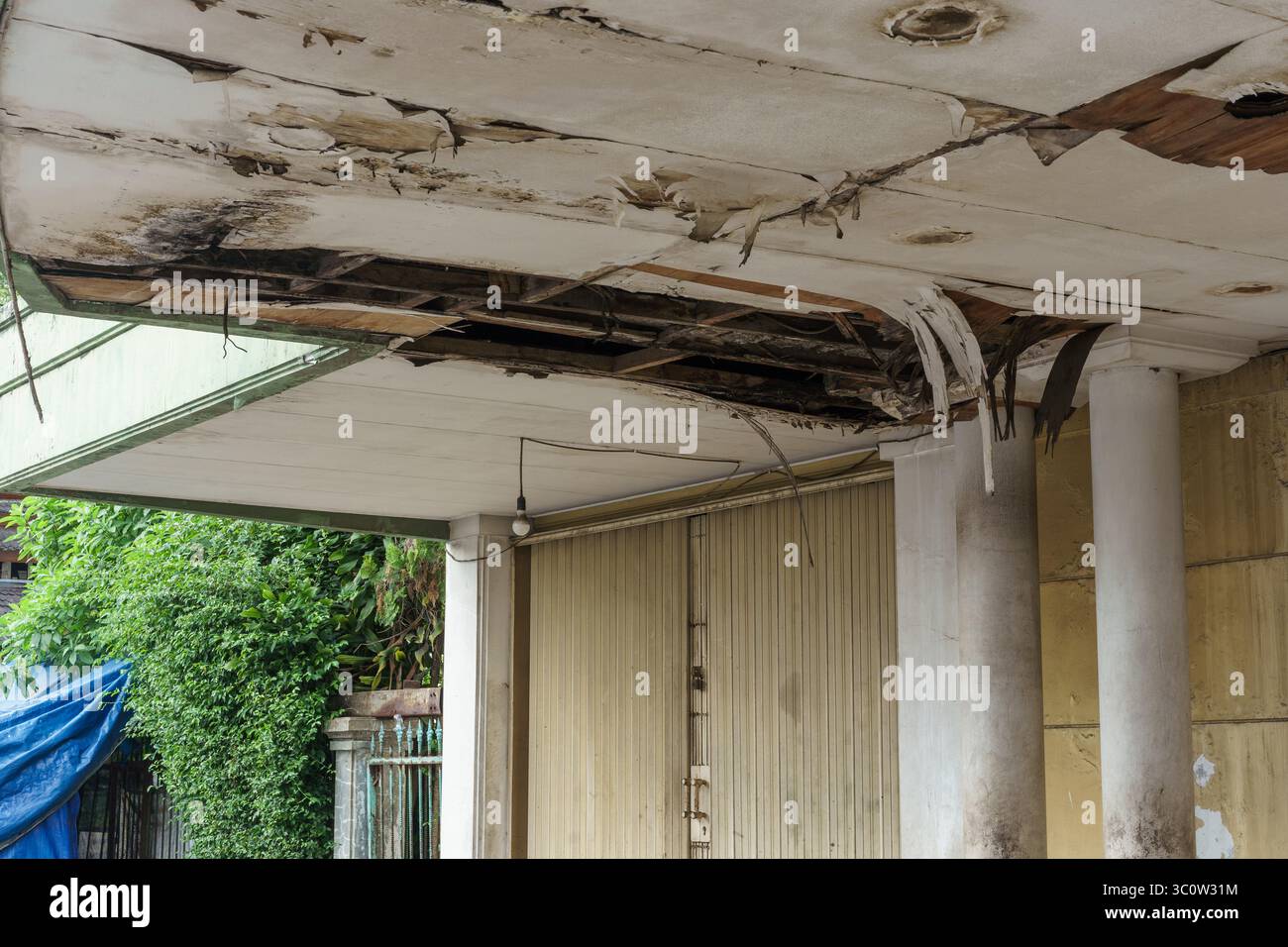 Plafond endommagé et écaillé avec des taches d'eau et des structures exposées dans un bâtiment abandonné. Concept de pourriture, de négligence et de nécessité de réparation. Banque D'Images