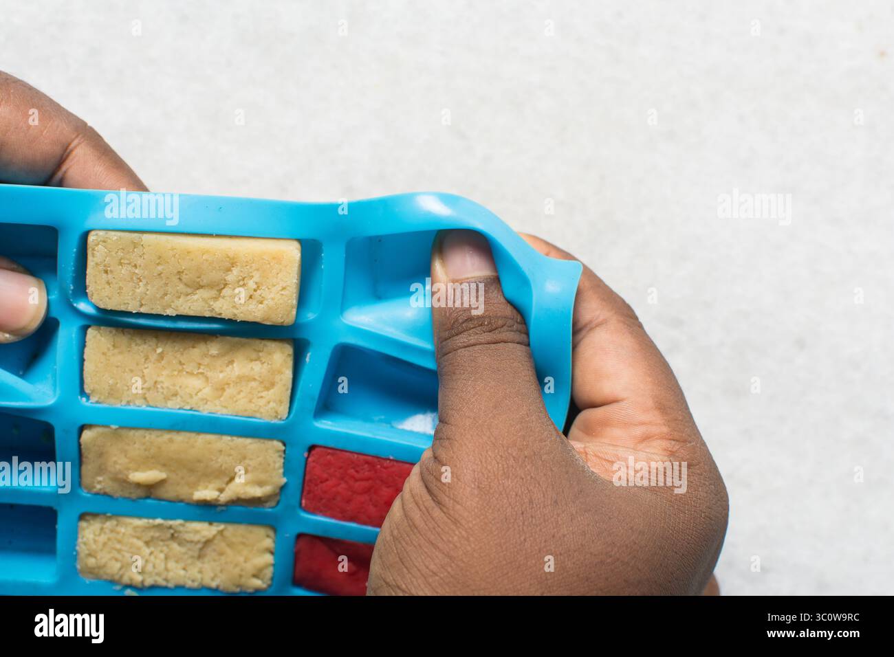 Vue aérienne de la pâte à biscuits au sucre rose vanille et fraise dans un moule en silicone, processus de fabrication de biscuits en damier Banque D'Images