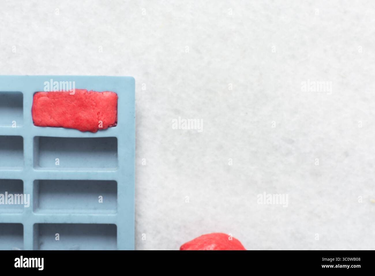 Vue aérienne de la pâte à biscuits au sucre rose vanille et fraise dans un moule en silicone, processus de fabrication de biscuits en damier Banque D'Images