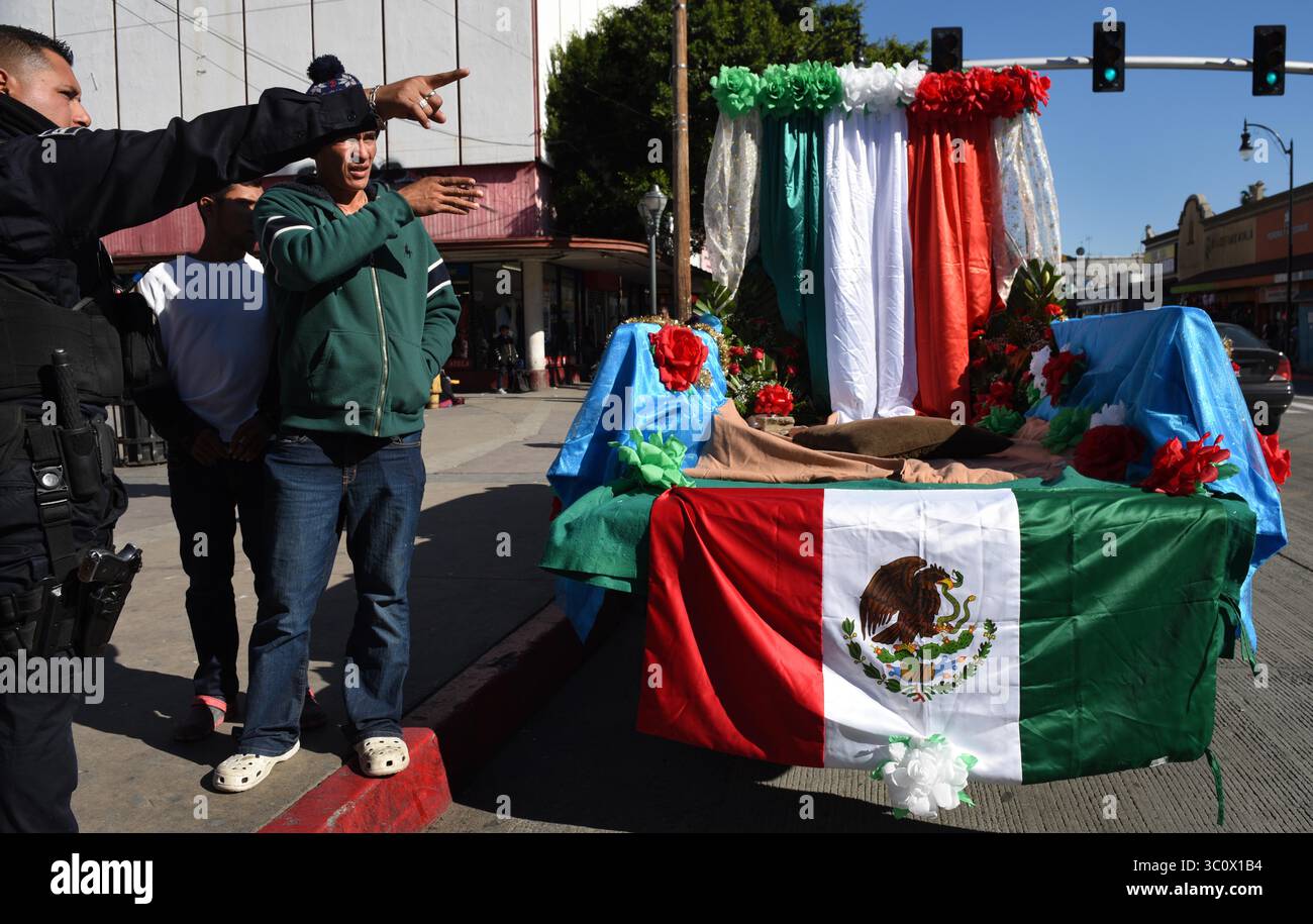 8 décembre 2018 - Tijuana, Mexique - JONATAN demande de l'aide pour trouver un deuxième bus pour la Playa. JONATAN MATAMOROS, 36 ans, a pris des bus du refuge Barretal pour caravanes migrantes d'Amérique centrale à la région pour chercher des endroits pour traverser vers les États-Unis éventuellement avec sa femme et son enfant. Il a vérifié les endroits possibles pour traverser la frontière à la Playas de Tijuana Mexique le 8 décembre 2018. Il regarde la frontière entre Tijuana et San Diego, les États-Unis si proches et pourtant si loin. Lui et sa femme SARA ARTIAGA, 31 ans, avec leur fils JOSE MIGUEL ARTIAGA, 18 mois, sont maintenant logés au refuge Barretal où ils attendront dans l'espoir de traverser Banque D'Images