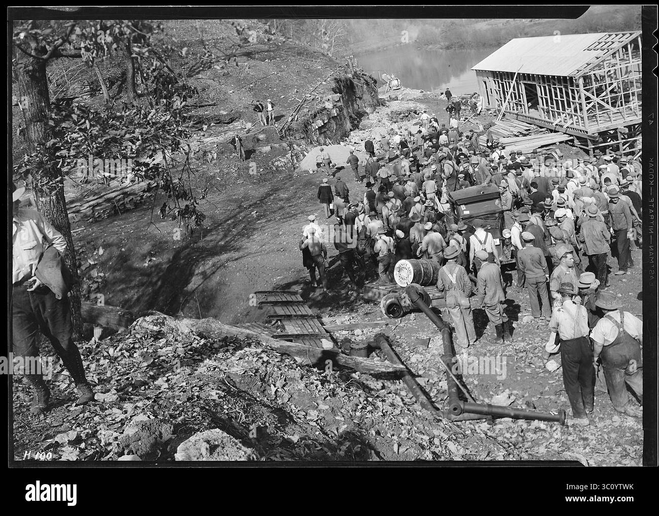 'Un groupe de travailleurs devant l'entrepôt partiellement construit juste en dessous du site du barrage Norris - Tennessee US, USA, Banque D'Images
