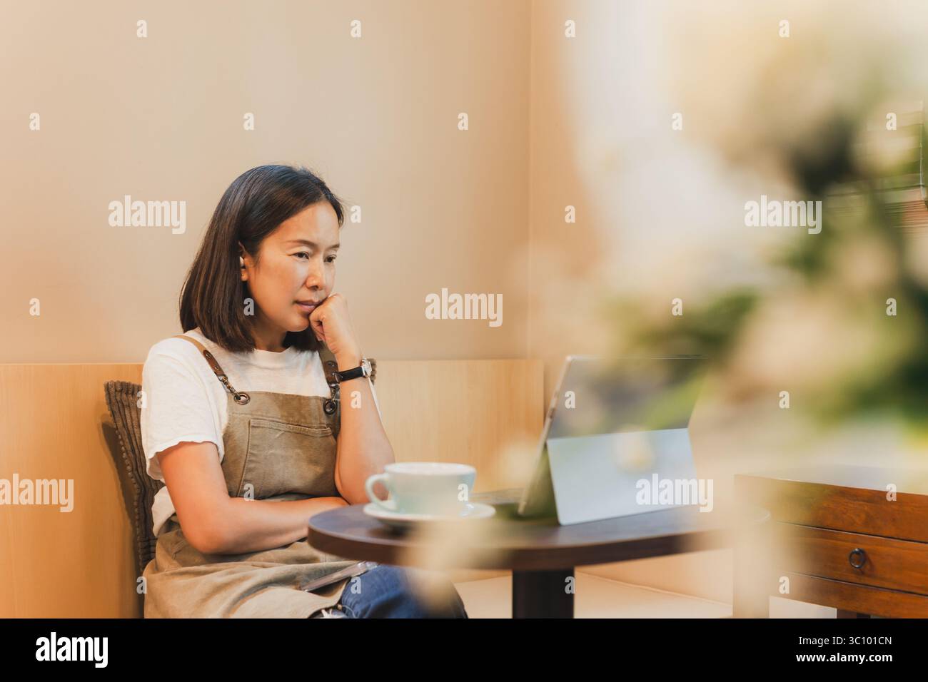 Femme asiatique propriétaire de café travaillant sur ordinateur portable dans le café. Banque D'Images