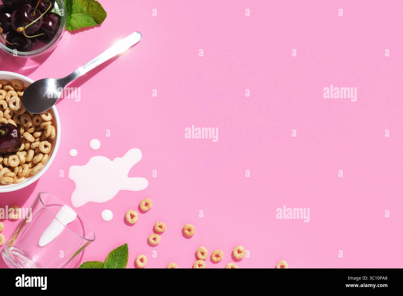 Fond de petit déjeuner rose avec anneaux de céréales, cerises, feuilles de menthe, une cuillère, lait renversé, et un bol. Espace pour votre texte. Banque D'Images Fond de petit déjeuner rose avec anneaux de céréales, cerises, feuilles de menthe, une cuillère, lait renversé, et un bol. Espace pour votre texte. Banque D'Images