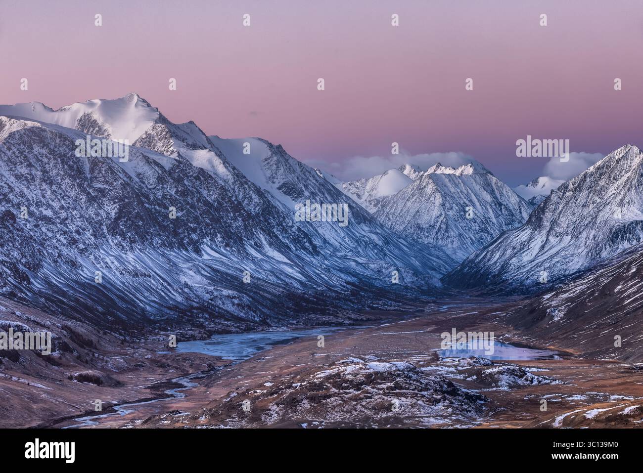 Vue sur les montagnes enneigées sous un ciel pastel créer un paysage serein et majestueux, République de l'Altaï, Russie. Banque D'Images