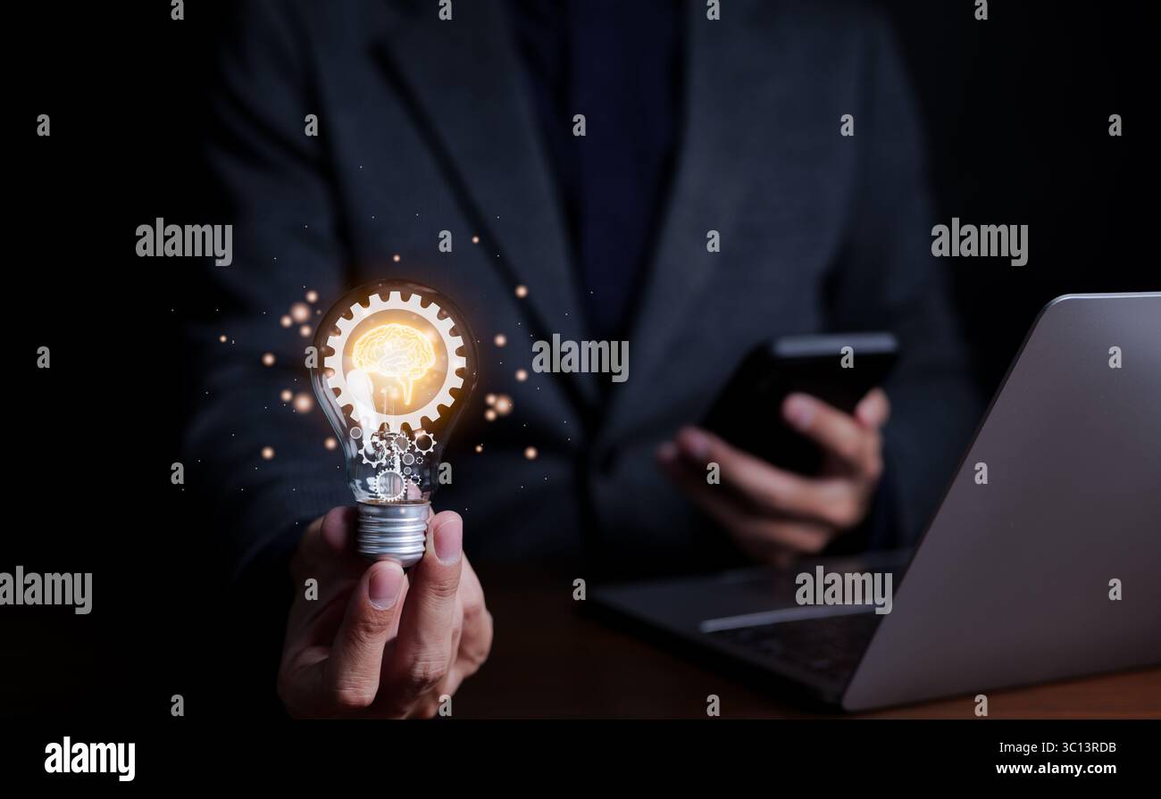 Motivation et innovation, homme d'affaires tenant une ampoule avec icône de cerveau et engrenages à l'intérieur. lumière éclatante, innovation et inspiration d'idées, Banque D'Images