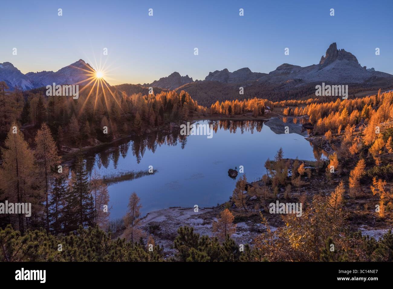 Vue du soleil doré éclatant sur les sommets des montagnes, illuminant le lac tranquille et le feuillage d'automne vibrant, créant une vue alpine époustouflante, lac Federa, Italie. Banque D'Images