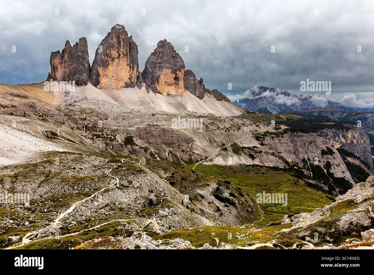 Vue des sommets déchiquetés de Tre Cime di Lavaredo percer le ciel, contrastant avec le terrain accidenté et les bruits de nuages, Dobbiaco, Trentino-Alto Adige, I Banque D'Images