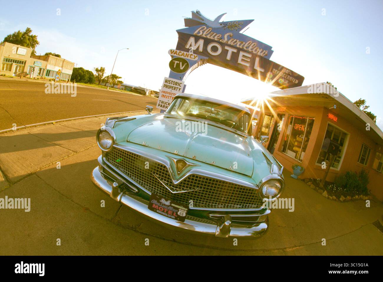 Tucumcari, Nouveau-Mexique, États-Unis. Blue Swallow Motel sur l'historique route 66 avec une vieille voiture bleue des années 1950 garée devant par temps clair. Banque D'Images