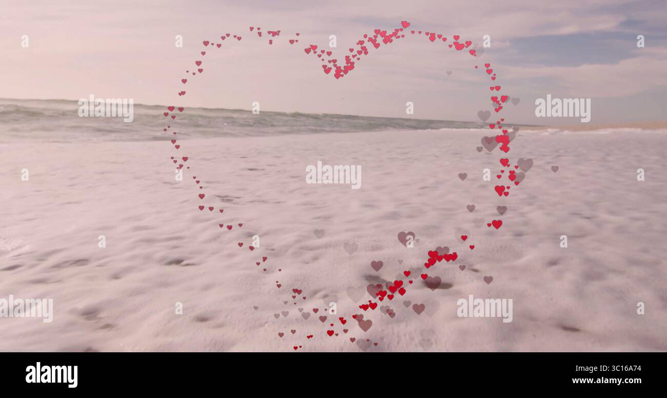 Regroupant de petites formes de coeur rouge et gris formant contour de coeur au rivage, avec des vagues de l'océan Banque D'Images