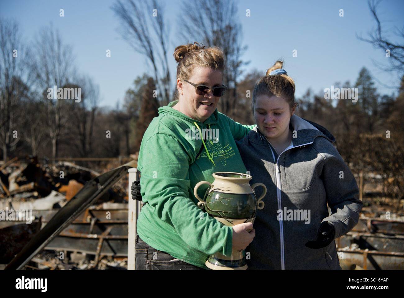 12 janvier 2019 - Paradise, CA, États-Unis - Chrissie Weston embrasse sa fille de 18 ans, Jayne, après que les cremains de ses grands-parents aient été retrouvés dans la maison Paradise de sa tante le 12 janvier 2019. On leur a présenté une urne faite à la main qui a été créée par des bénévoles. En utilisant l'aide d'un chien entraîné à sentir les restes humains, les indices de la famille et l'analyse de la couleur et de la texture, les crémains peuvent être distingués parmi les cendres de la propriété des gens. Les cremains sont ensuite donnés à la famille afin qu'ils ne soient pas envoyés dans une décharge de déchets toxiques. Le groupe espère que leur travail sera reconnu b Banque D'Images
